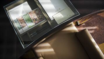 Une pièce moderne avec une cloison en verre sur laquelle est affiché un menu, ainsi qu’une petite table sur laquelle se trouve également un menu.
