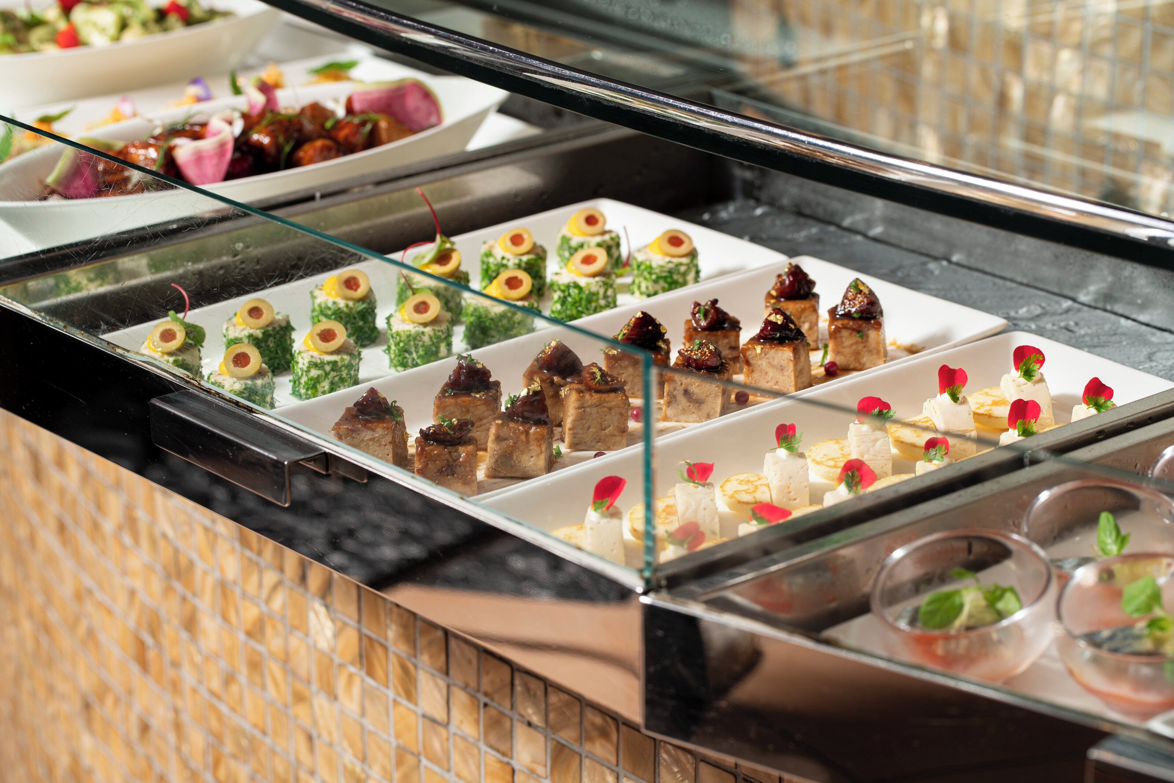 Un buffet proposant une variété de plats, notamment des pâtisseries et des desserts, présentés sur des assiettes.