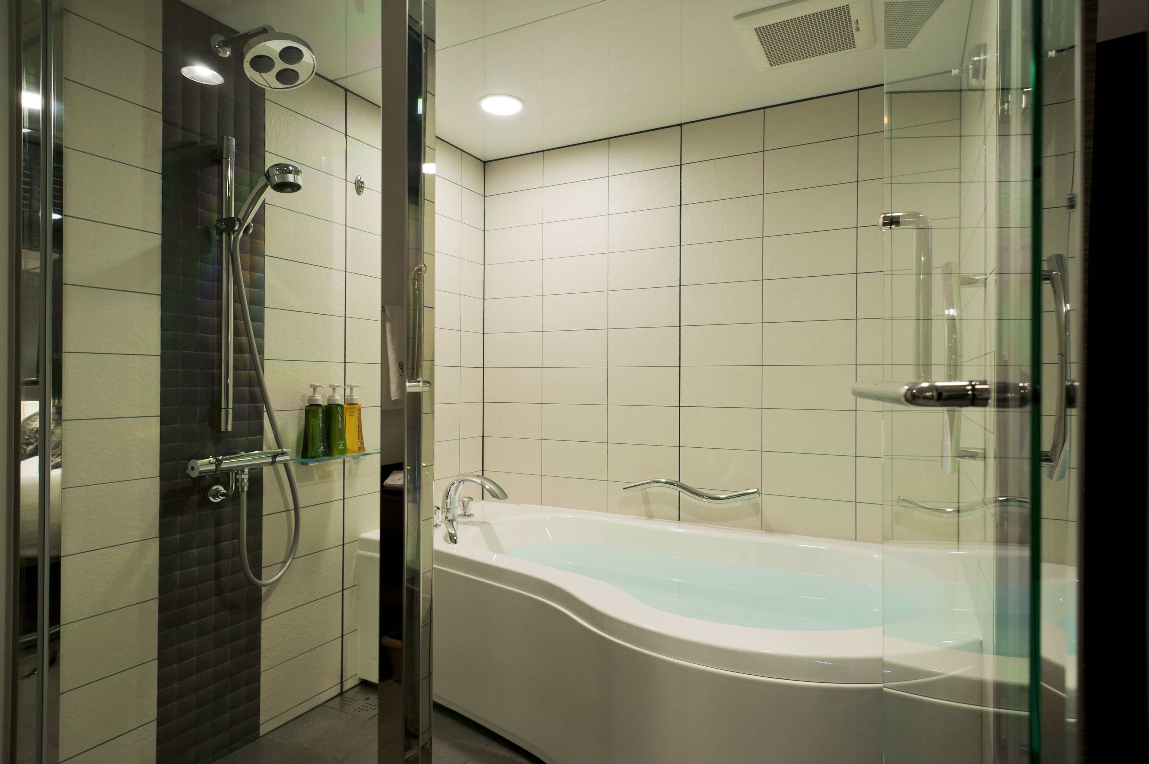 A modern bathroom with a glass-enclosed shower, a freestanding bathtub, and a glass shower enclosure.
