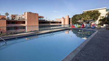 Una piscina al aire libre, tumbonas