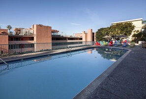 Una piscina al aire libre, sillones reclinables de piscina