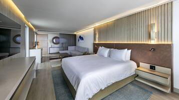 A modern hotel room with a large bed, a sofa, a desk, and a TV.