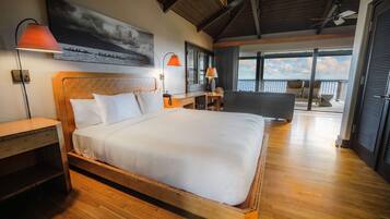 Ein geräumiges Schlafzimmer mit einem großen Bett, einem Holzkopfende und Blick auf den Balkon.