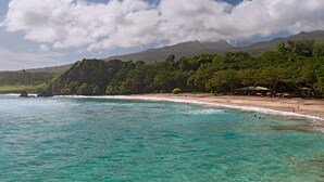 A beach with clear turquoise waters, a sandy shore, and lush green hills in the background. - Hana-Maui Resort, a Destination by Hyatt Residence (Hana)
