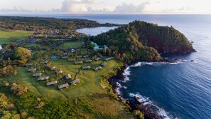 An aerial view of a coastal resort with multiple buildings, a golf course, and a view of the ocean. - Hana-Maui Resort, a Destination by Hyatt Residence (Hana)