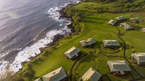 An aerial view of a coastal golf resort with multiple buildings, a well-maintained golf course, and a rocky shoreline. - Hana-Maui Resort, a Destination by Hyatt Residence (Hana)