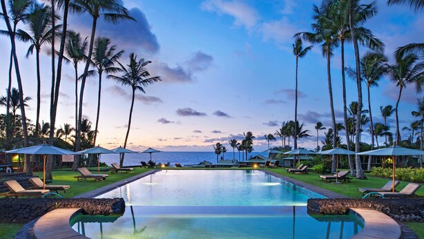 A pool area with lounge chairs and umbrellas, surrounded by palm trees and overlooking the ocean. - Hana-Maui Resort, a Destination by Hyatt Residence (Hana)