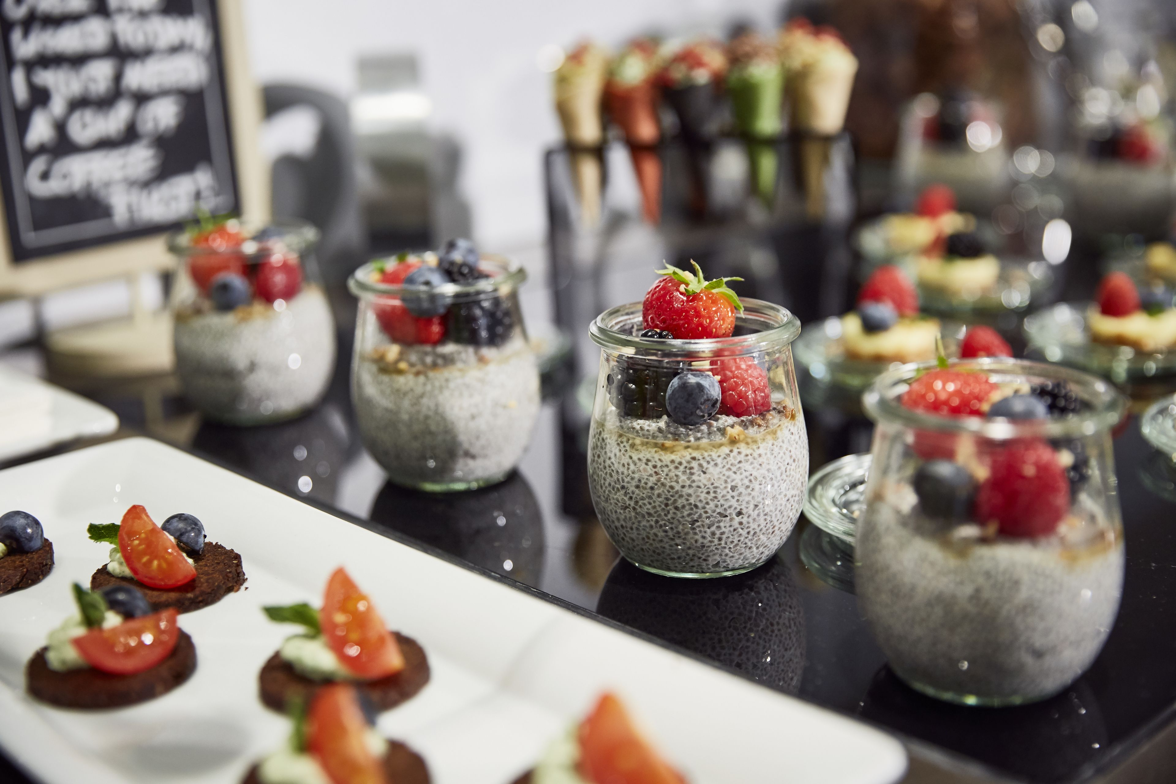 Eine Auswahl an Desserts, darunter Chiasamenpudding mit Beeren und weitere süße Leckereien.