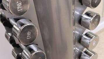A close-up of a metallic dumbbell rack with weight markers.