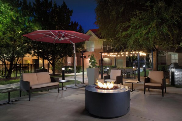 An outdoor patio area with a fire pit, seating, and string lights. - Residence Inn By Marriott San Antonio Airport/Alamo Heights (San Antonio)