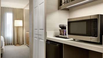 Une chambre d’hôtel moderne équipée d’un four à micro-ondes, d’une machine à café et d’un lave-vaisselle.