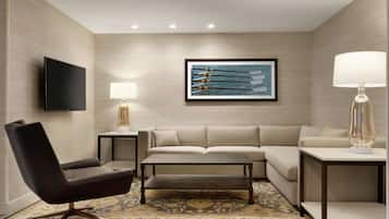 A modern living room with a sofa, a coffee table, a chair, a TV, and a lamp.