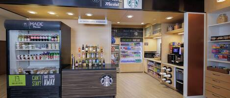 Made Market -myymälä, jossa on Starbucks-logo, hyllyt täynnä pikkupurtavaa ja erillinen osasto, josta voi ottaa tuotteita mukaan.