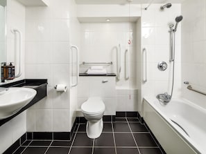 Une salle de bain moderne avec un lavabo, des toilettes et une baignoire, le tout de couleur blanche.