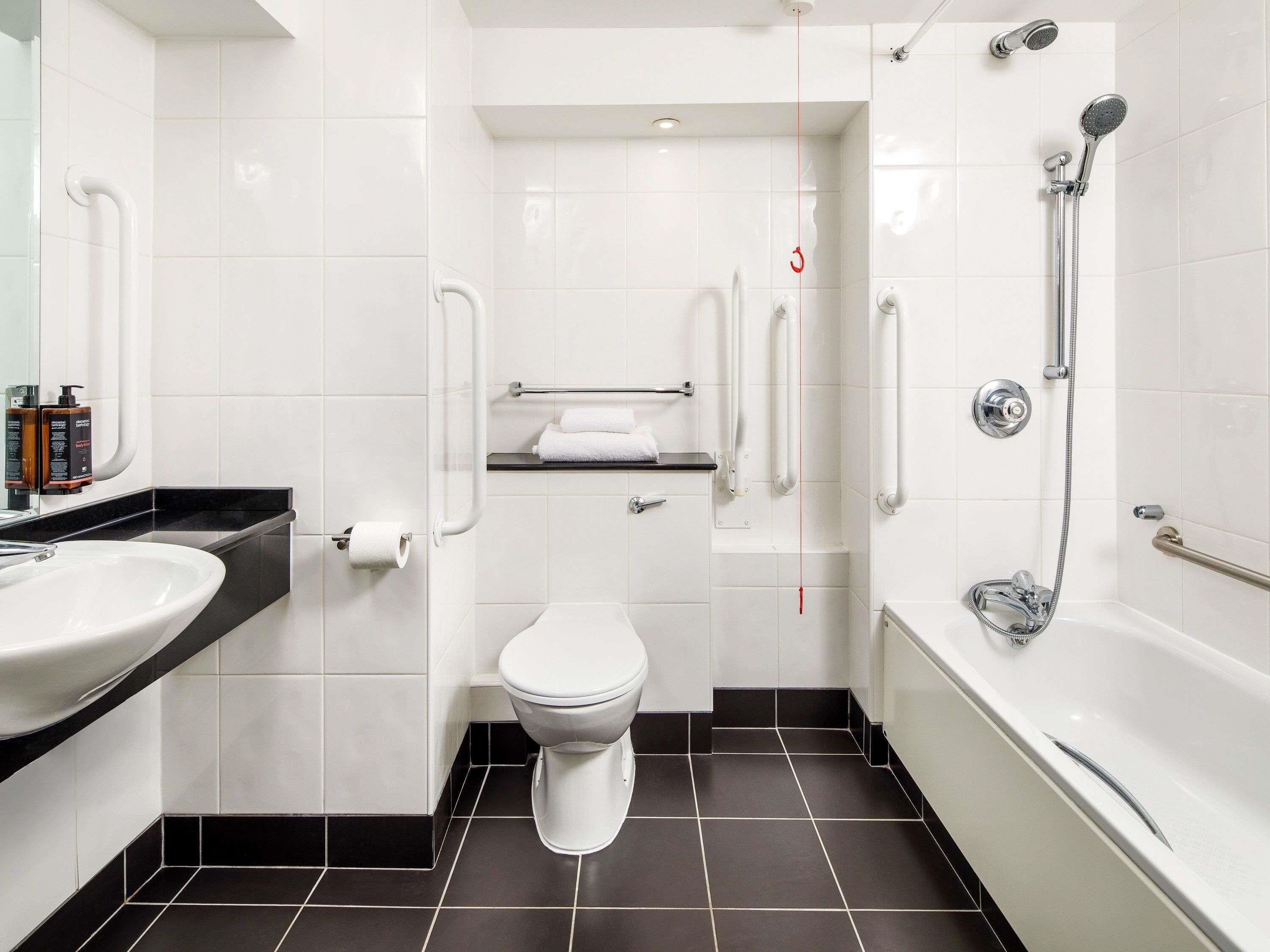 A modern bathroom with a toilet, sink, and bathtub.