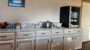 Eine Küchenzeile mit Kühlschrank, Mikrowelle und verschiedenen Küchenger äten.