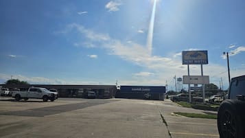 A parking lot with a motel sign, a building labeled 'Landoll Lanes', and a clear sky.