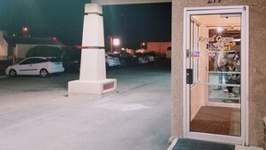 A hotel entrance with a numbered door, a parking lot, and a streetlight in the background. - Budget Host Royal Gorge Inn (Canon City)