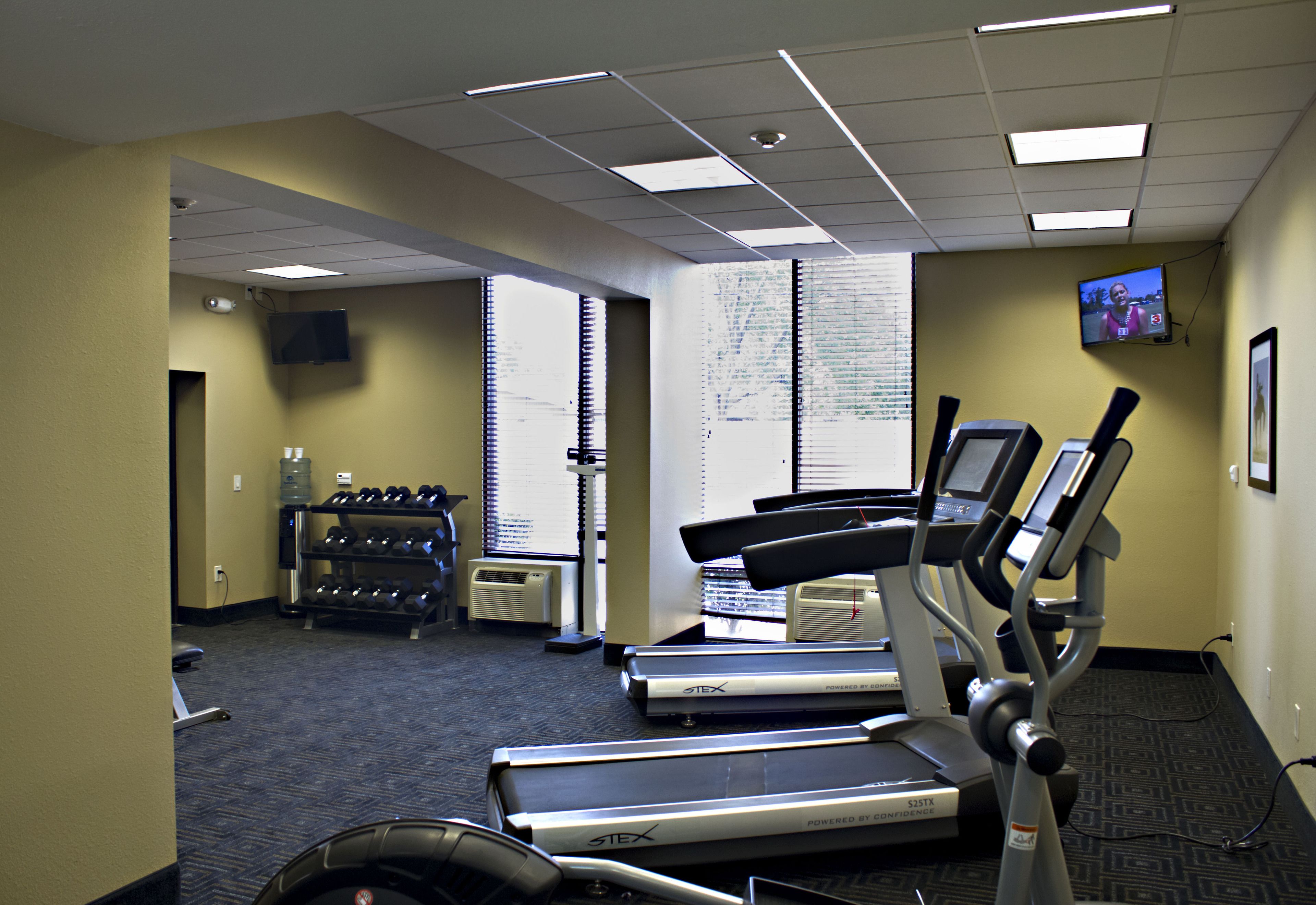 A gym with treadmills, a stationary bike, and a wall-mounted TV.