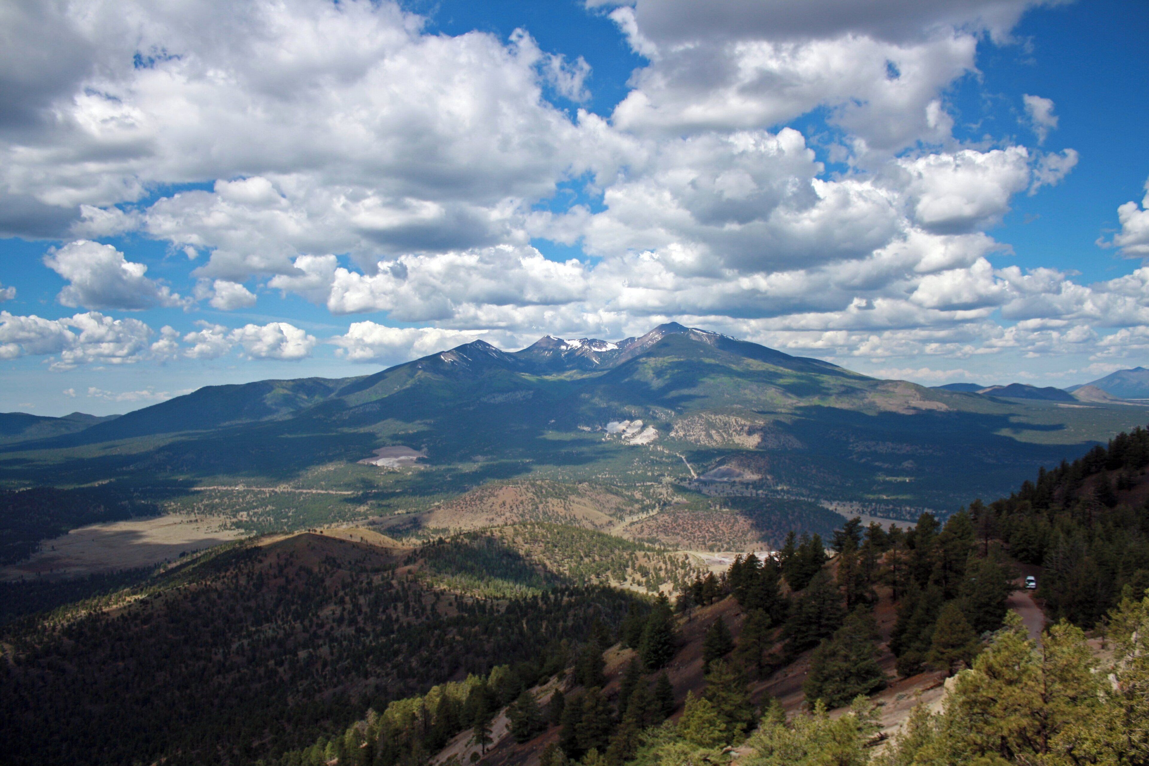 A mountainous landscape with a clear sky and scattered clouds.