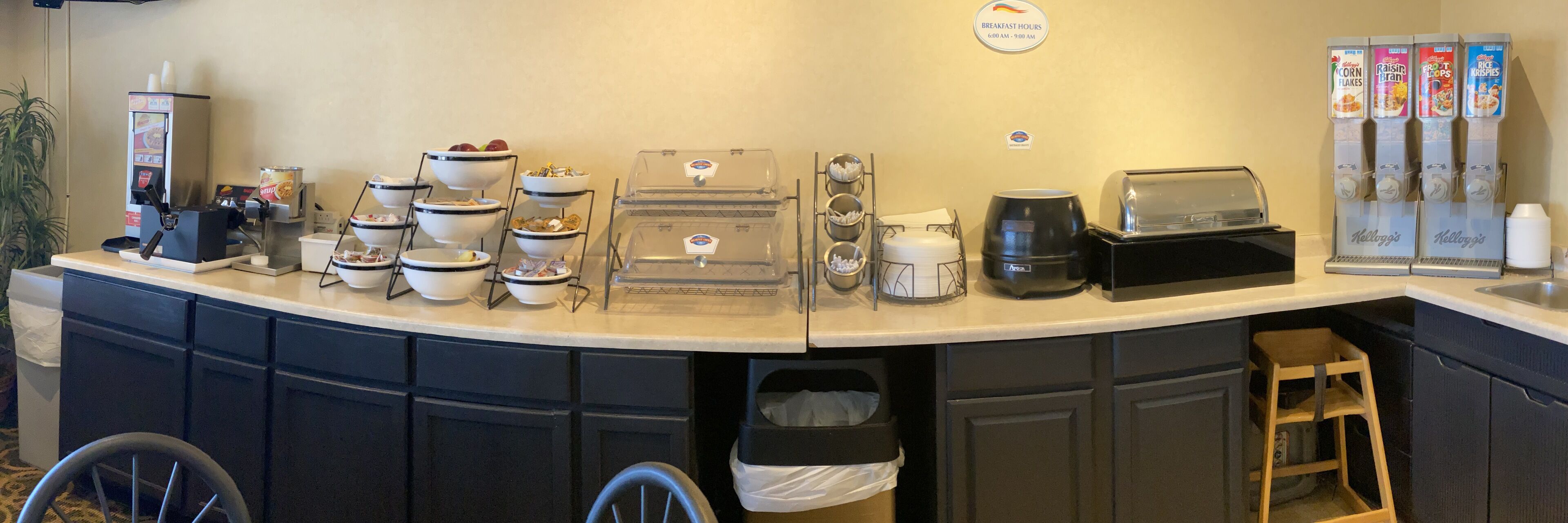 Een ontbijtbuffet met diverse etenswaren, zoals ontbijtgranen, koffie en een koffiezetapparaat.