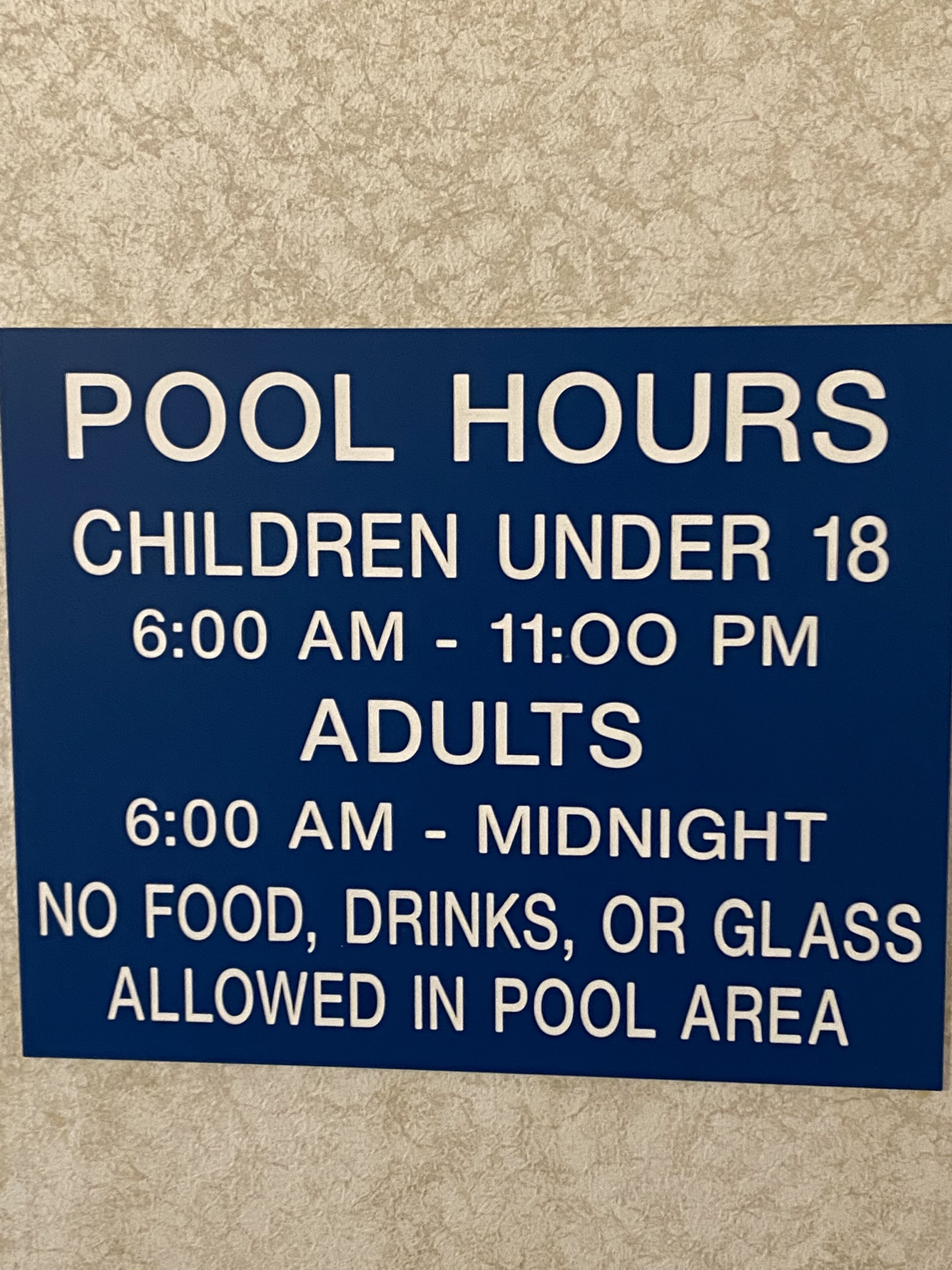 A sign detailing pool hours and rules.