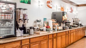 A breakfast bar with a refrigerator, coffee maker, toaster, and various food items.