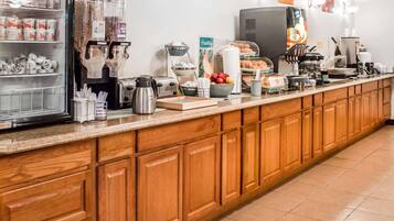 Un comptoir-repas équipé d’un réfrigérateur, d’une machine à café, d’un grille-pain et de divers produits alimentaires.