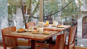 A breakfast table set with plates of food, a glass of orange juice, and a pitcher of milk. - Best Western Premier Hotel Dante (Barcelona)