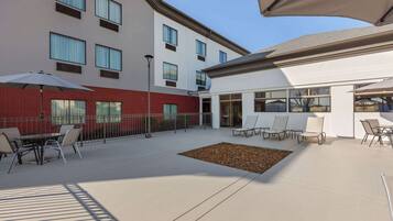 An outdoor patio area with seating and a small garden bed.