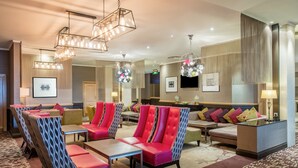 A hotel lobby with seating areas, a reception desk, and modern lighting fixtures. - Crowne Plaza Chester by IHG (Chester)