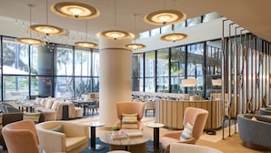A spacious lobby with multiple seating areas, large windows, and modern pendant lighting. - Marriott Long Beach Downtown (Long Beach)