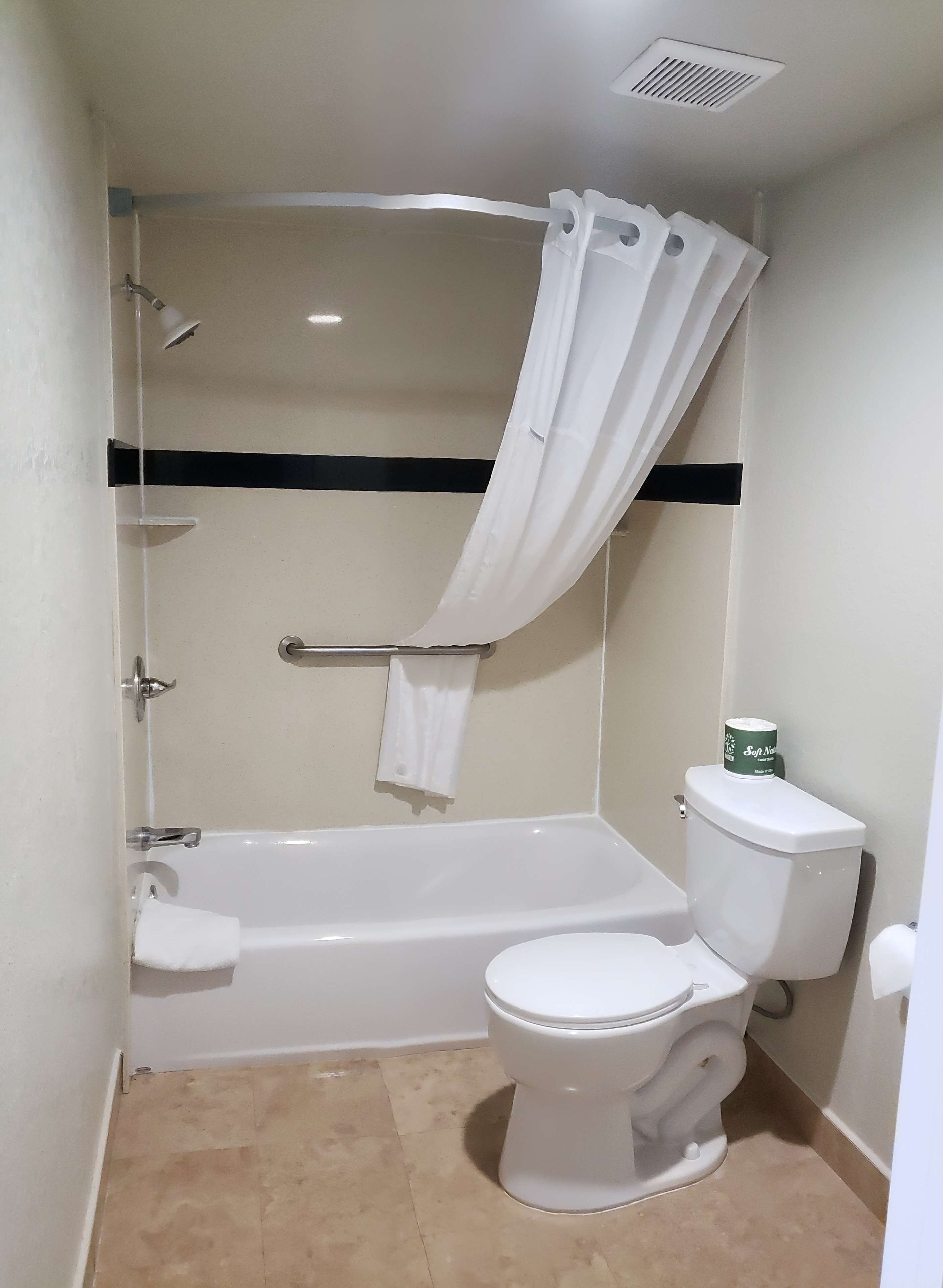 Ein Badezimmer mit Badewanne, Toilette und Duschvorhang.