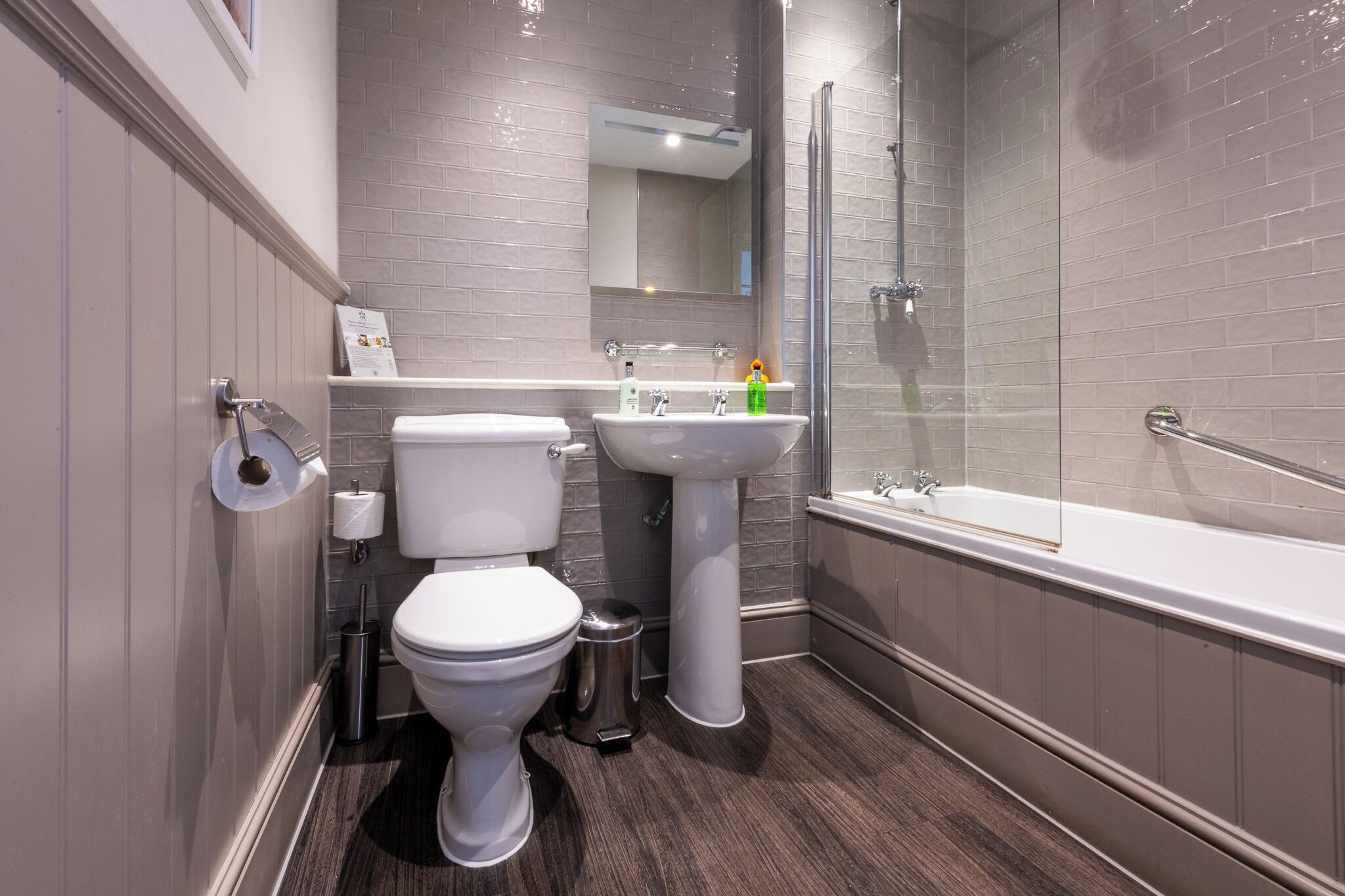 A modern bathroom with a toilet, sink, and bathtub.