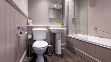A modern bathroom with a toilet, sink, and bathtub.