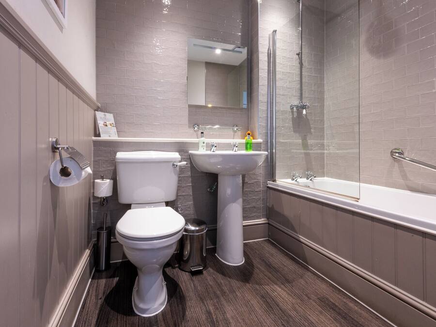 A modern bathroom with a toilet, sink, and bathtub.