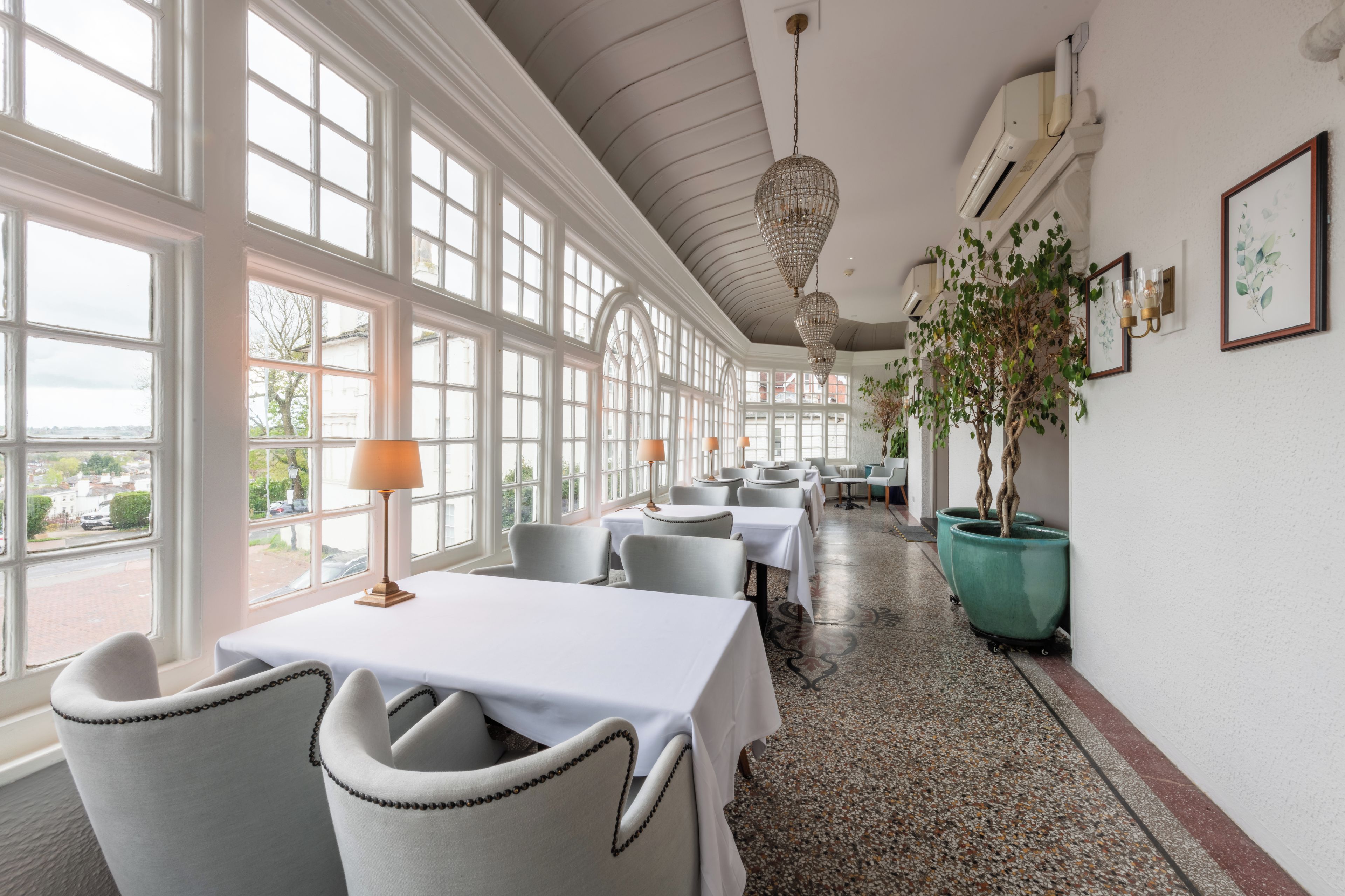 Un restaurant avec des tables recouvertes de nappes blanches, des chaises et un long comptoir.