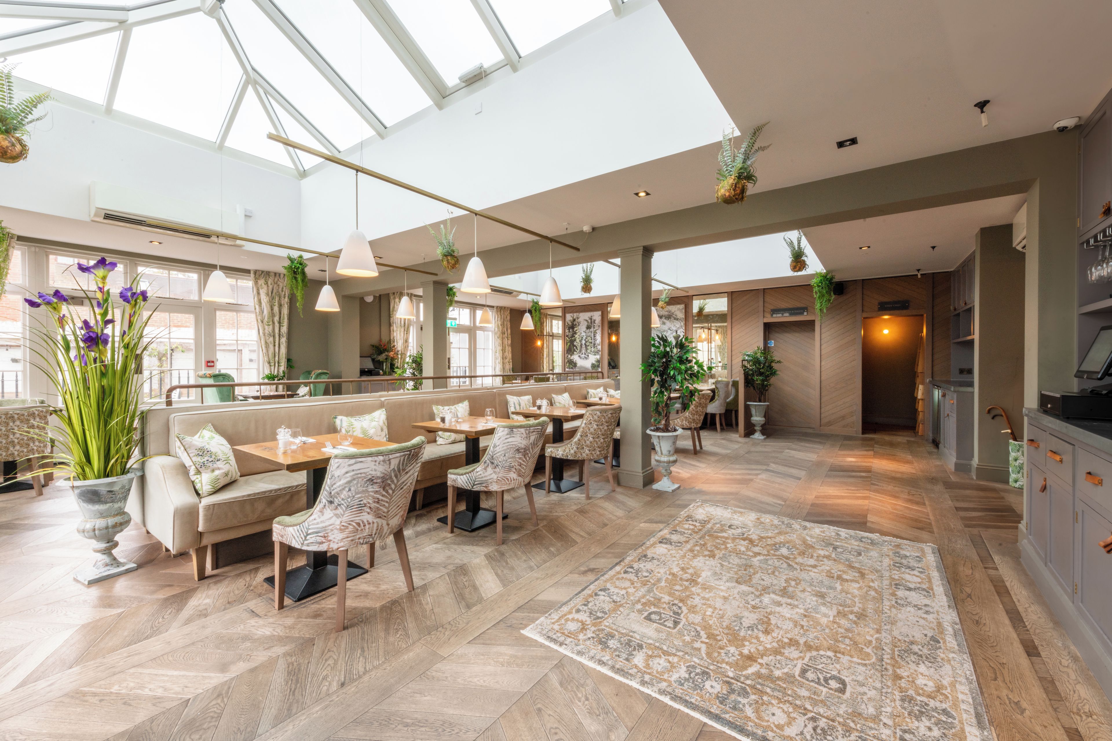 A spacious indoor area with high ceilings, large windows, and a variety of seating arrangements including tables and chairs.