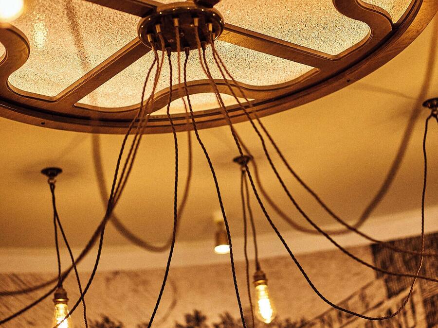 Un candelabro con varias bombillas y una pared con un letrero.