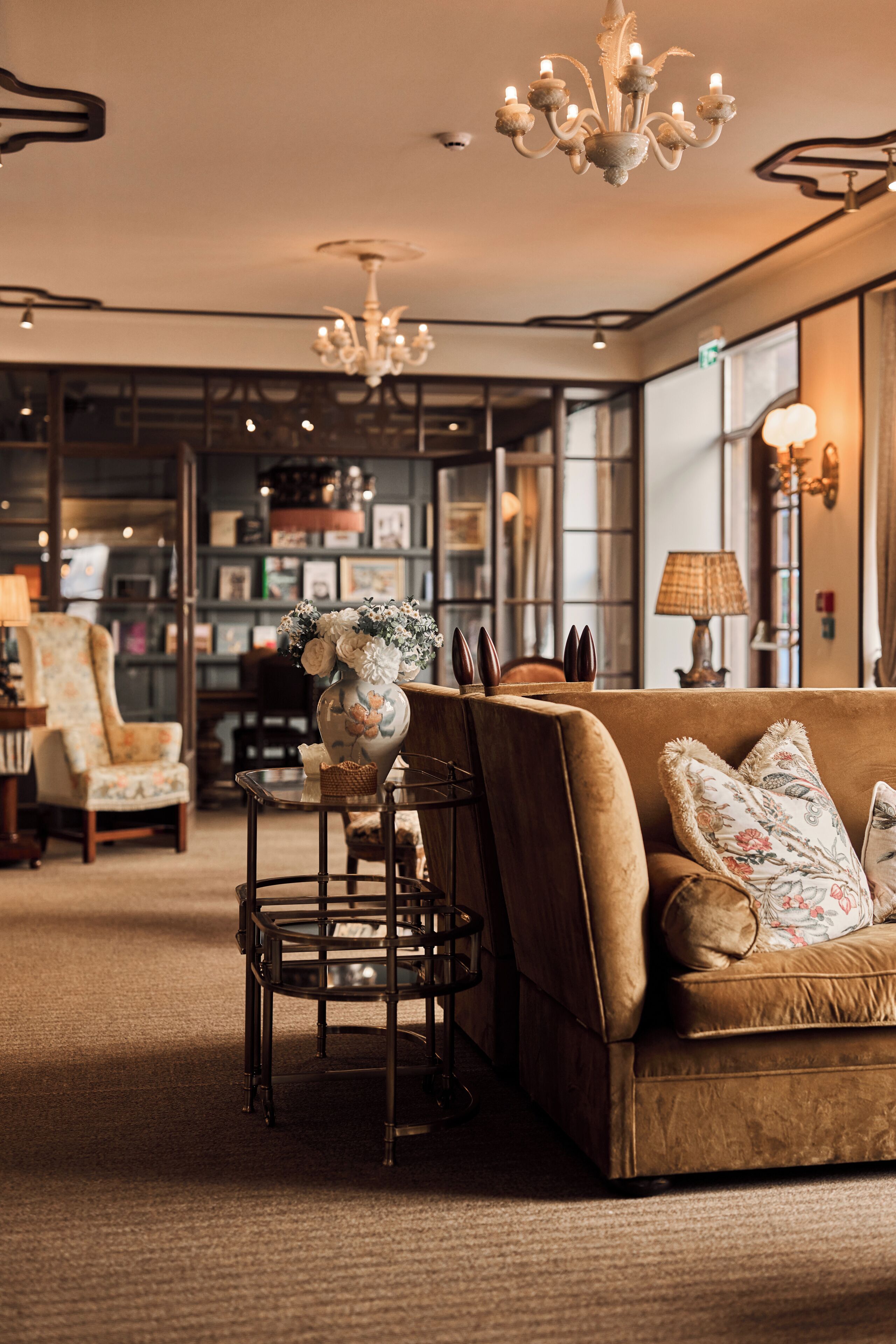 A cozy lounge area with a sofa, a round table, and a chandelier.