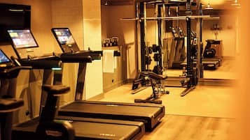 A gym with treadmills, a weight machine, and a mirror.
