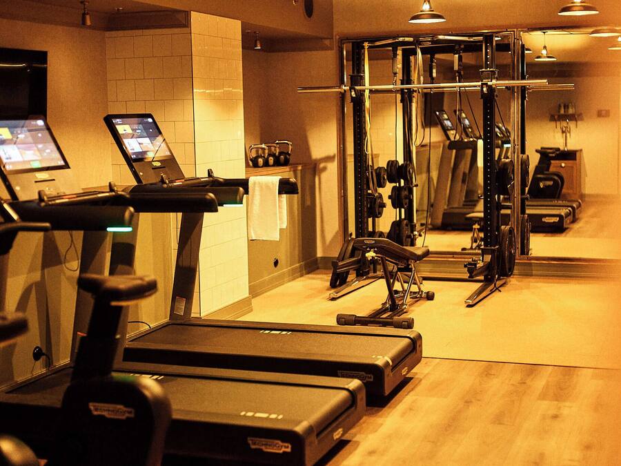 A gym with treadmills, a weight machine, and a mirror.