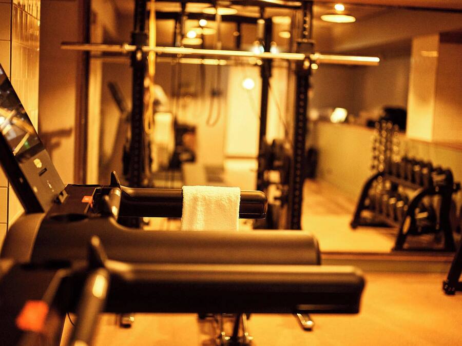 A gym with exercise equipment and a mirror.