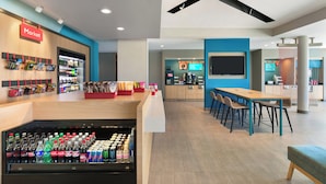 A modern indoor space with a market area, seating, and a counter. - avid Hotel Ocala Downtown by IHG (Ocala)
