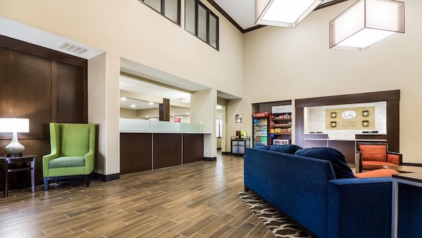A hotel lobby with a reception desk, seating area, and vending machines. - Comfort Suites Sioux Falls Mall District (Sioux Falls)