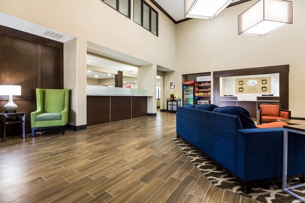 A hotel lobby with a reception desk, seating area, and vending machines. - Comfort Suites Sioux Falls Mall District (Sioux Falls)