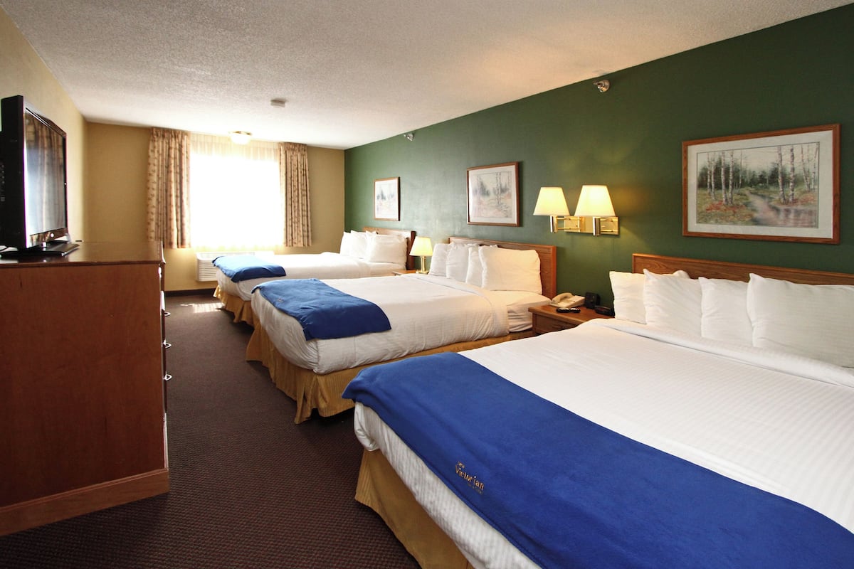 Suite, varias camas (Triple Queen) | Escritorio, espacio para trabajar con laptop y cortinas blackout