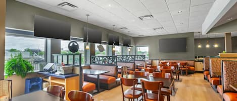 A spacious restaurant with multiple seating areas, including booths and tables.