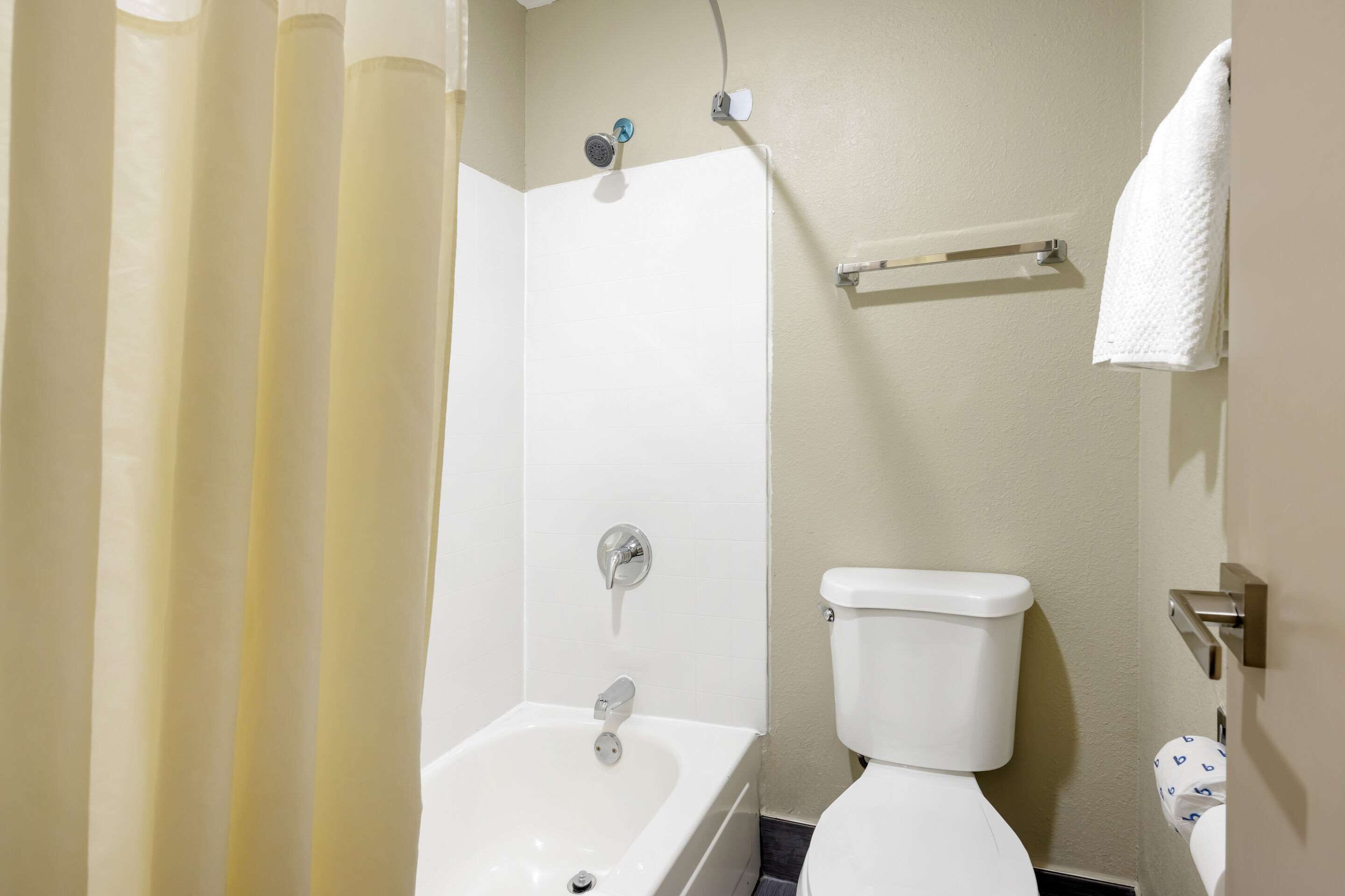 A bathroom with a bathtub, toilet, and shower curtain.
