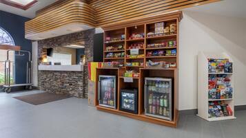 Un quiosco autoservicio con dispensadores de bebidas refrigeradas y estantes con snacks.